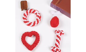 Set de cuatro juguetes de cuerda para perros. Juego de cuatro juguetes de cuerda para perros en rojo y blanco, incluye anillo, baqueta, corazón y hueso, para masticar.